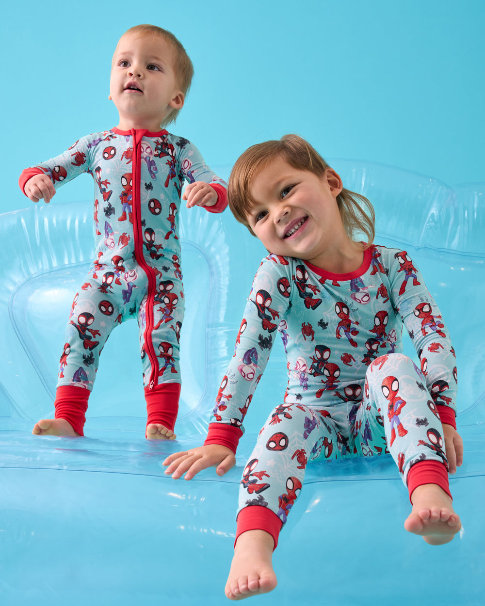 Two boys wearing matching Spidey & Friends Tiny Webs pajamas