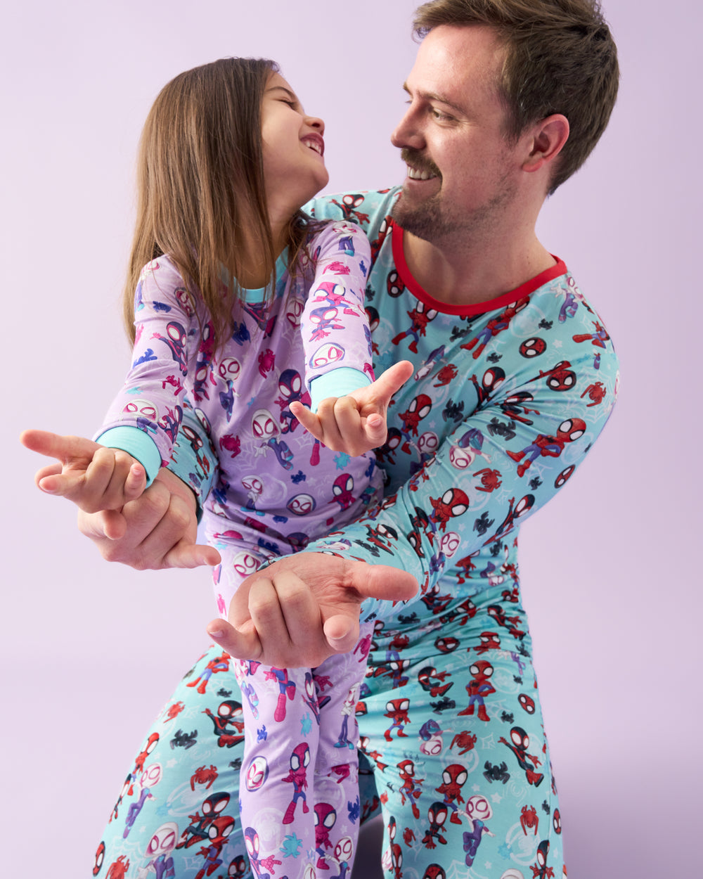 Father and daughter wearing matching Spidey & Friends Tiny Webs pajamas