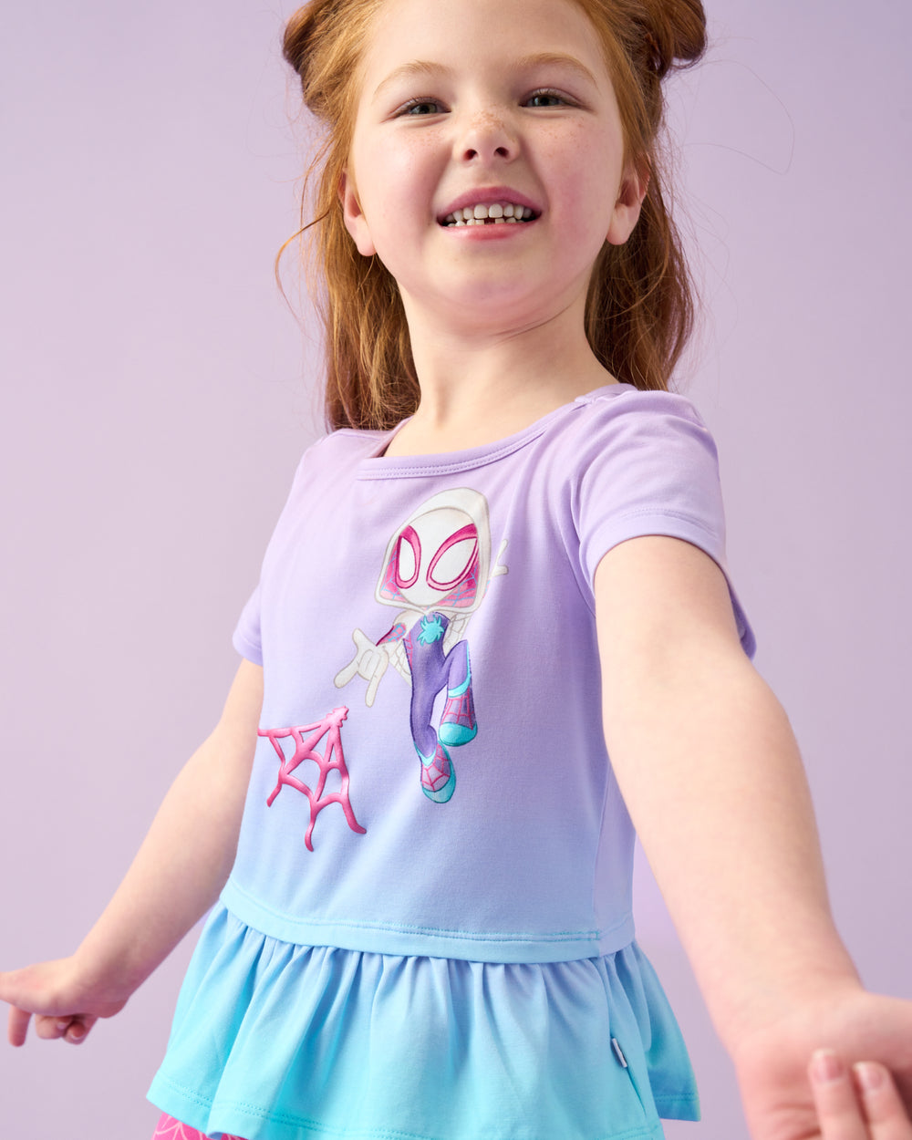 Close up of girl wearing the Spidey & Friends Ghost Spidey Peplum Top on a purple back drop