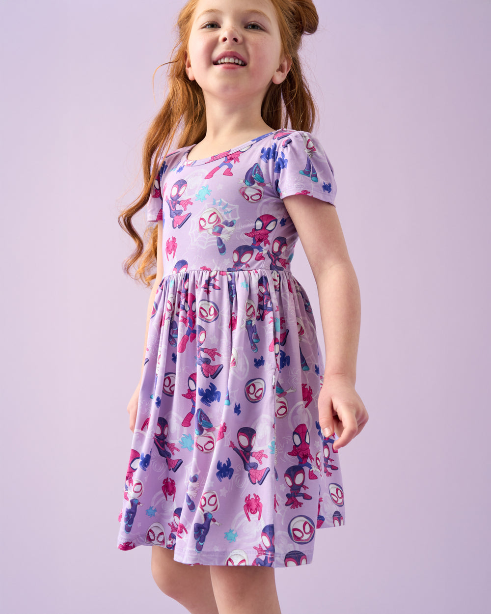 Girl wearing the Spidey & Friends Tiny Webs Skater Dress on a purple back drop