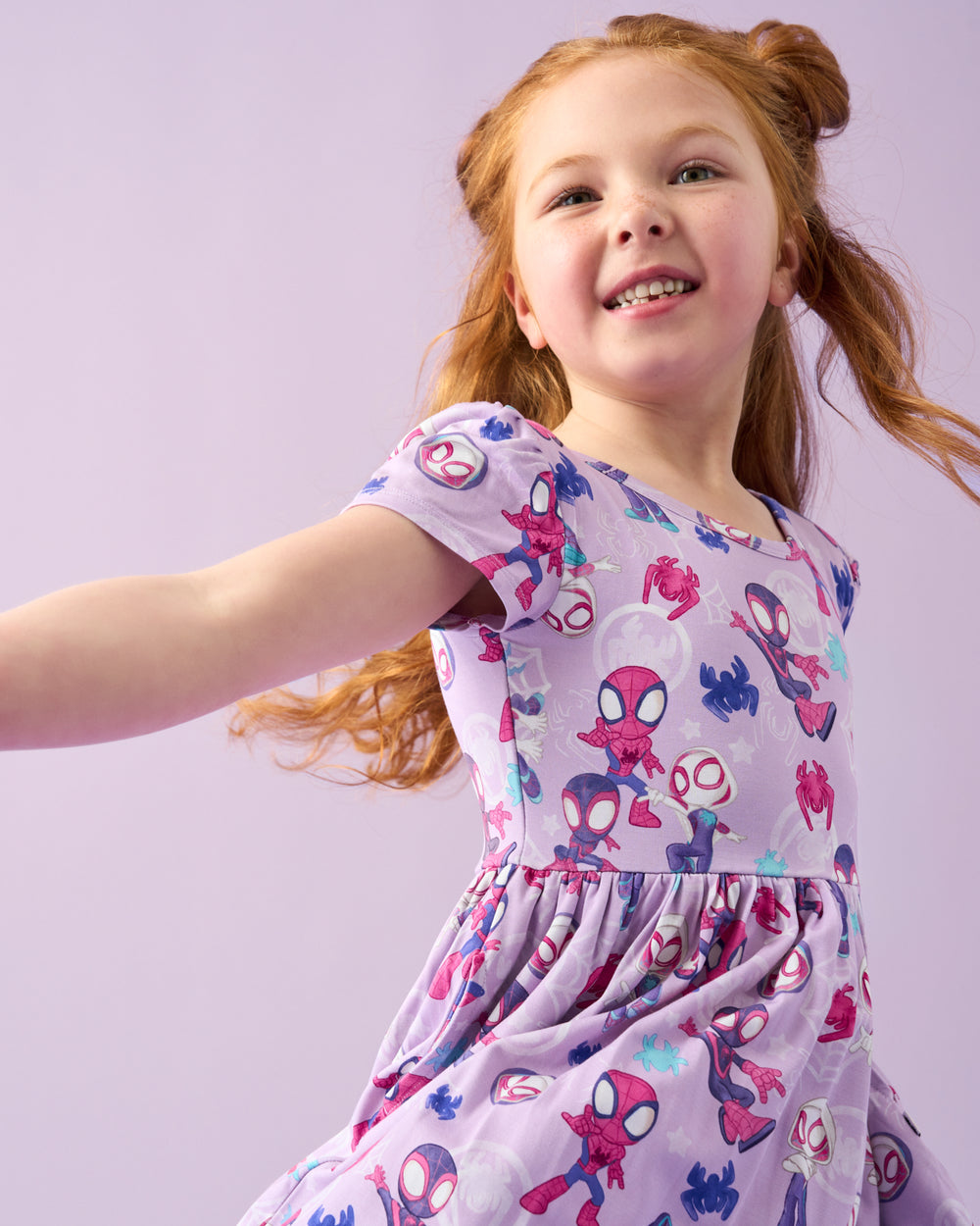 Close up of girl wearing the Spidey & Friends Tiny Webs Skater Dress on a purple back drop