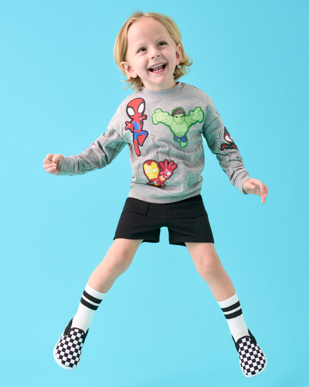Jumping boy wearing the Spidey & Friends Mighty City Heroes Crewneck Sweatshirt with black shorts