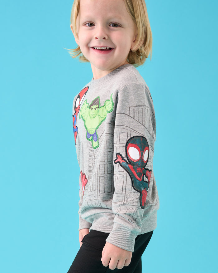 Boy wearing the Spidey & Friends Mighty City Heroes Crewneck Sweatshirt on a blue back drop