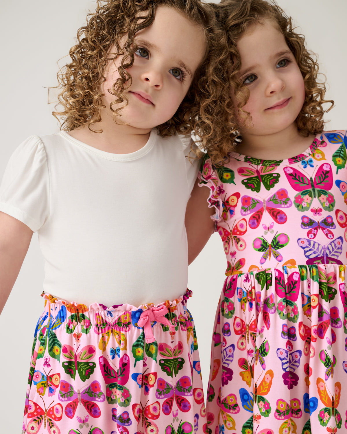 Two girls wearing matching Flutter Garden play styles