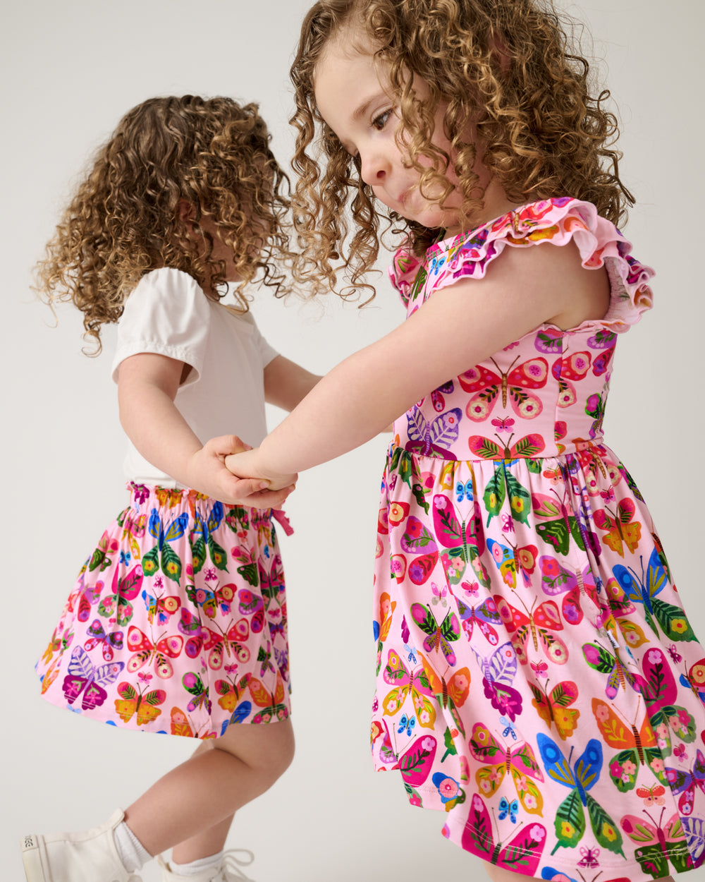 Two children wearing matching Flutter Garden play styles