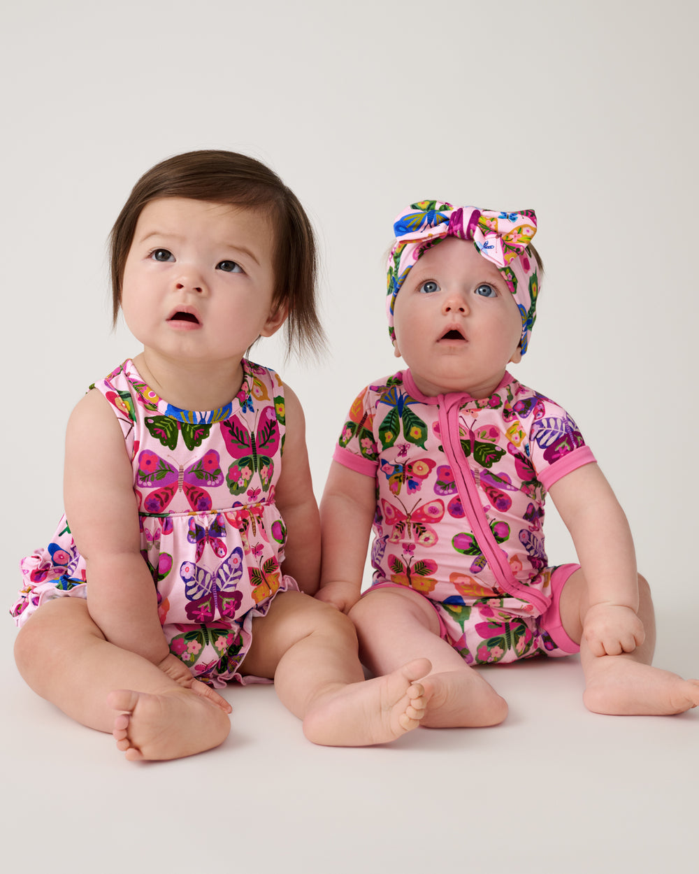 Two babies wearing matching Flutter Garden Play and Sleep styles