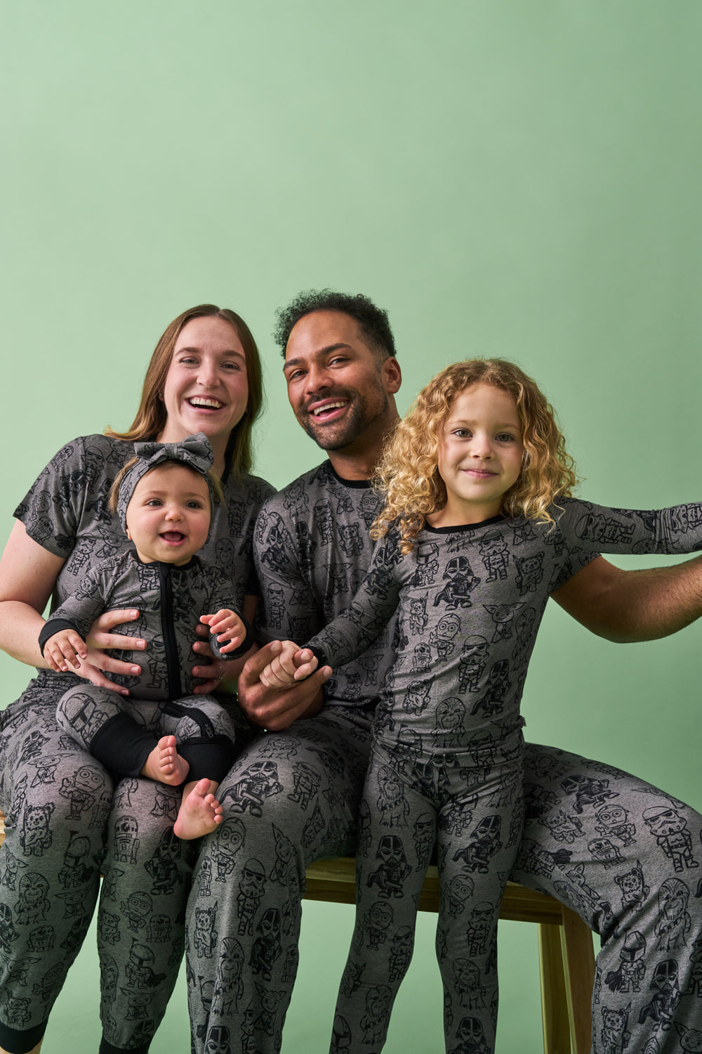 Family of four wearing matching Star Wars Far, Far, Away Friends Pajamas