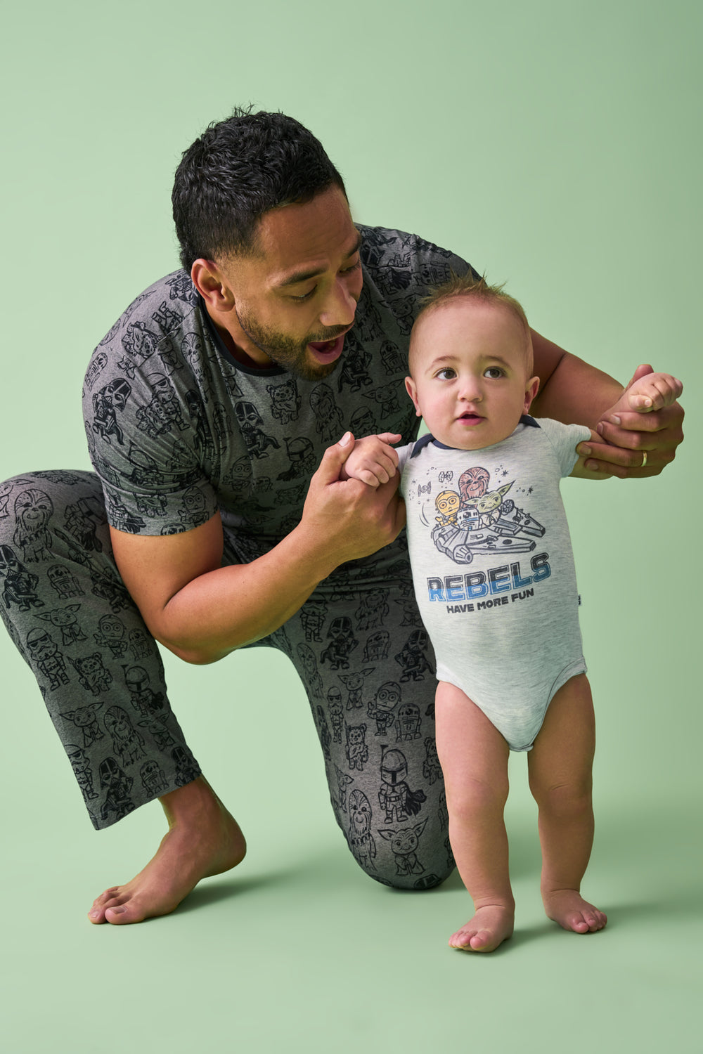 Father and son wearing Star Wars Far, Far, Away Friends styles on a green back drop