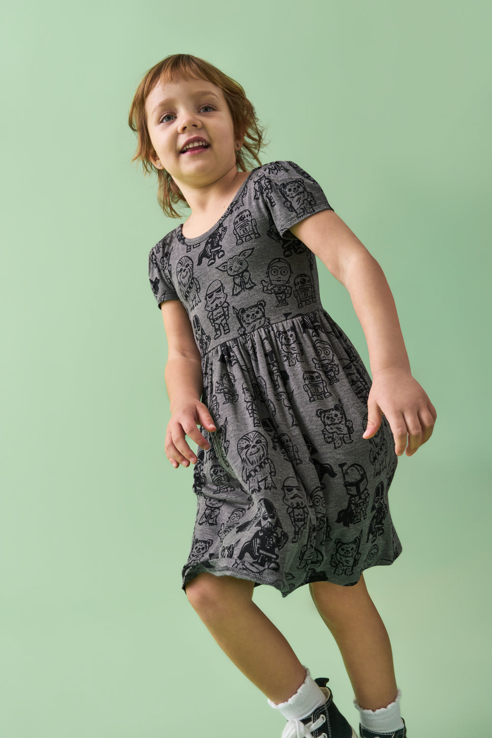 Child wearing the Star Wars Far, Far, Away Friends Skater Dress on a green back drop