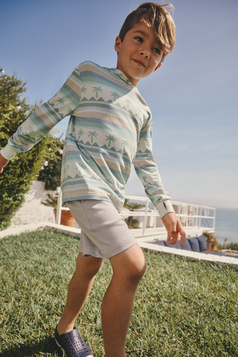 Boy wearing the Swell Stripes Hooded Tee in a backyard