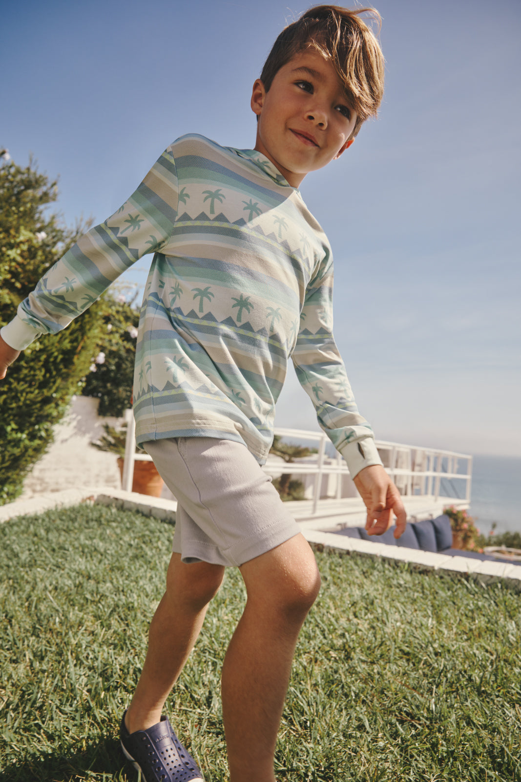 Boy wearing the Swell Stripes Hooded Tee in a backyard