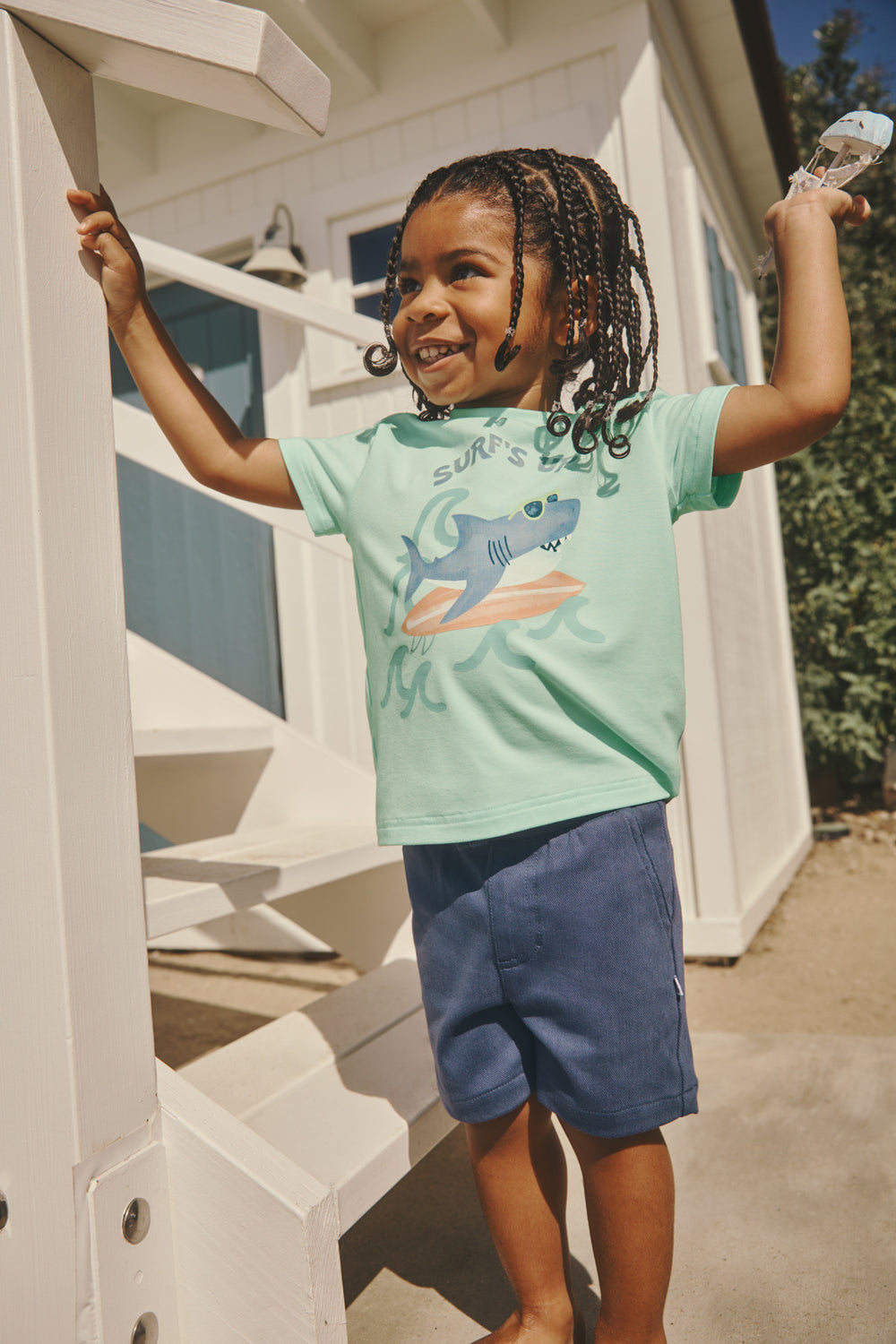 Boy wearing the Surf's Up Relaxed Tee with a beach cottage in the background