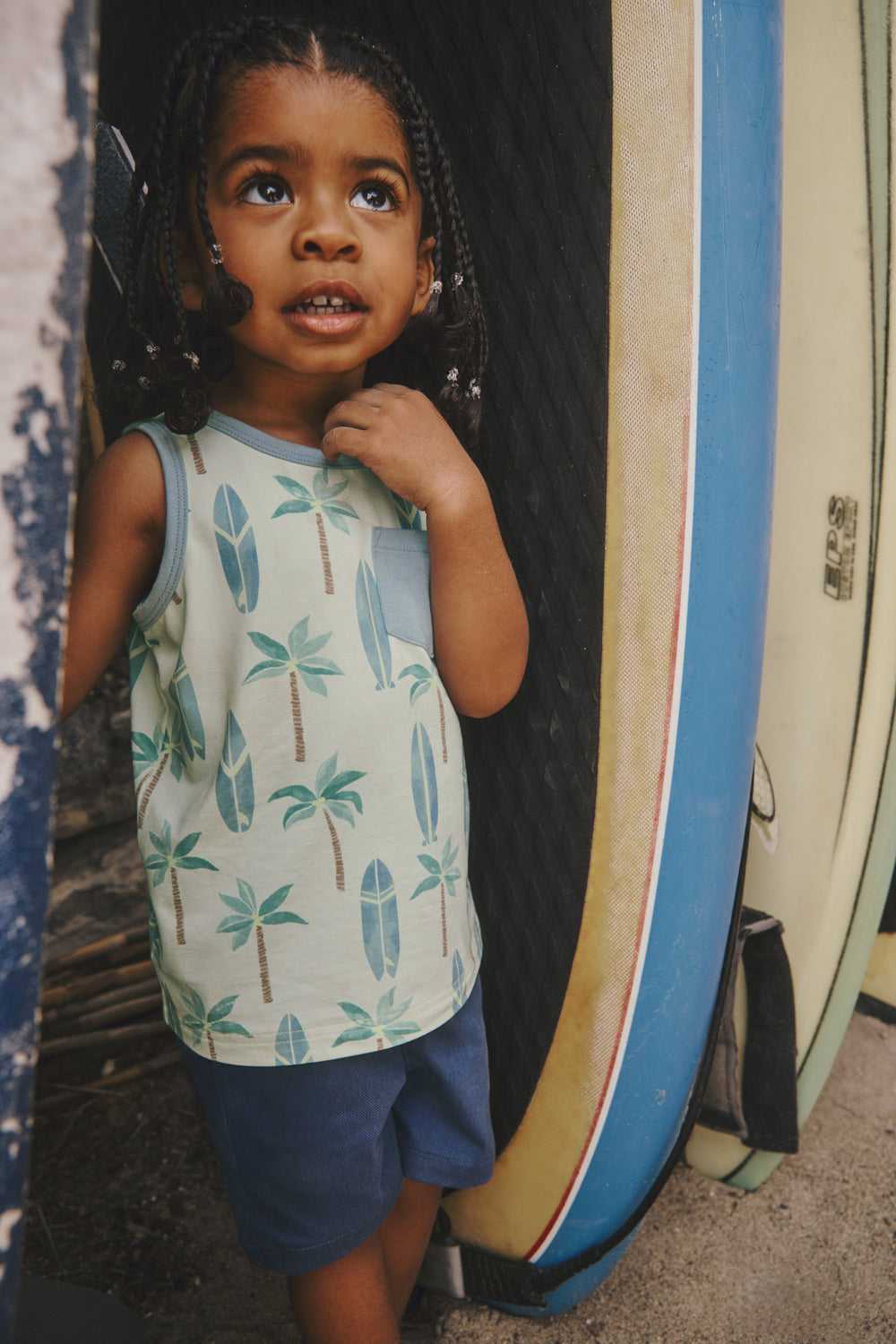 Boy standing next to surfboards in the Palm Dunes Pocket Tank