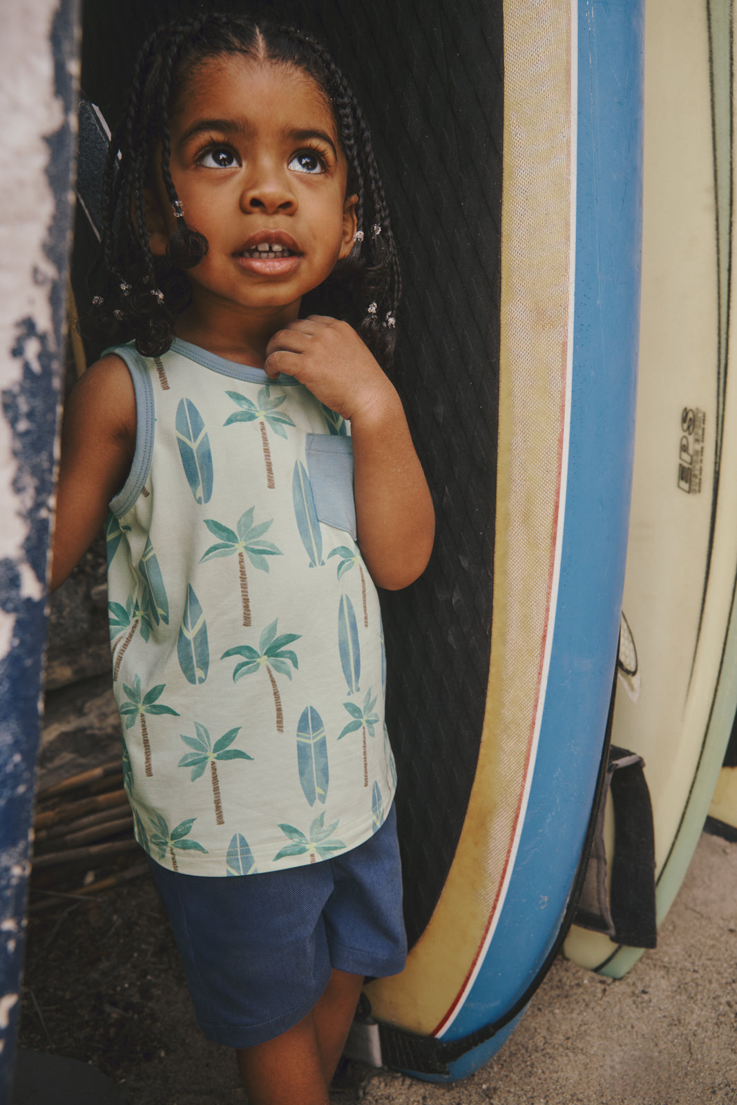 Boy standing next to surfboards in the Palm Dunes Pocket Tank