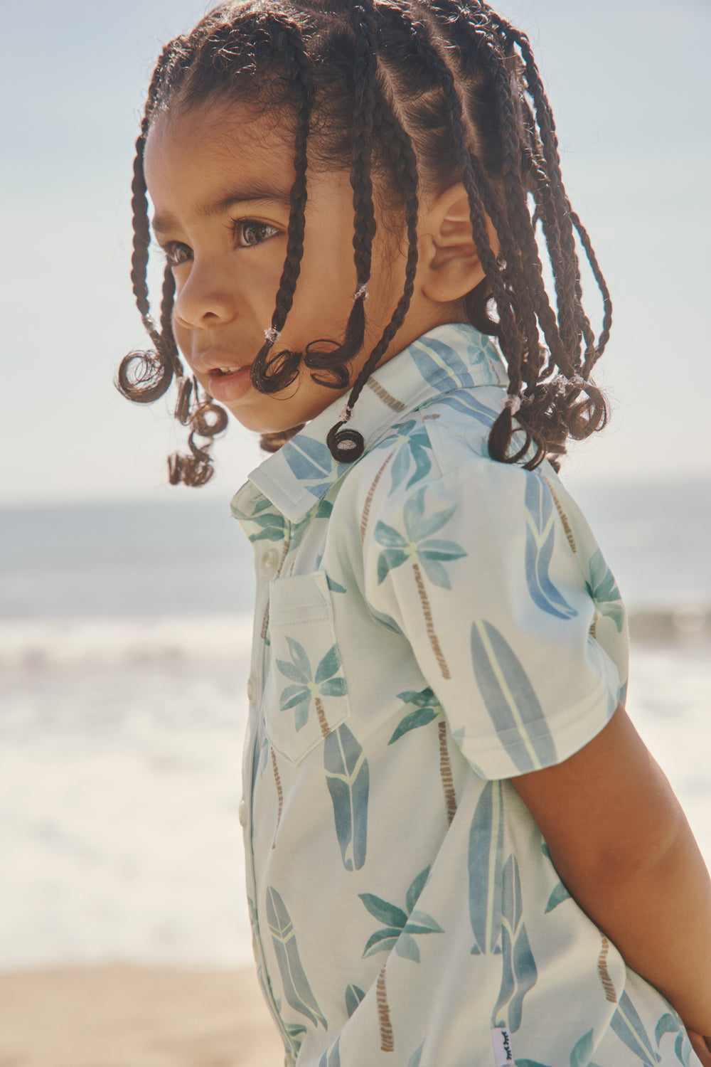 Close up of boy wearing the Palm Dunes Button Down Polo at the beach