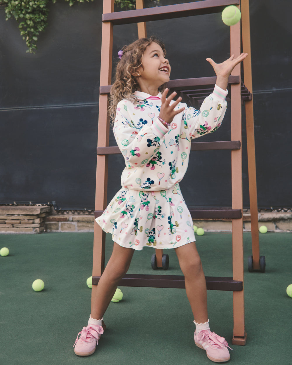 Girl wearing the Disney Mickey Mouse & Minnie Mouse Match Pleated Skort and Crewneck on a tennis court