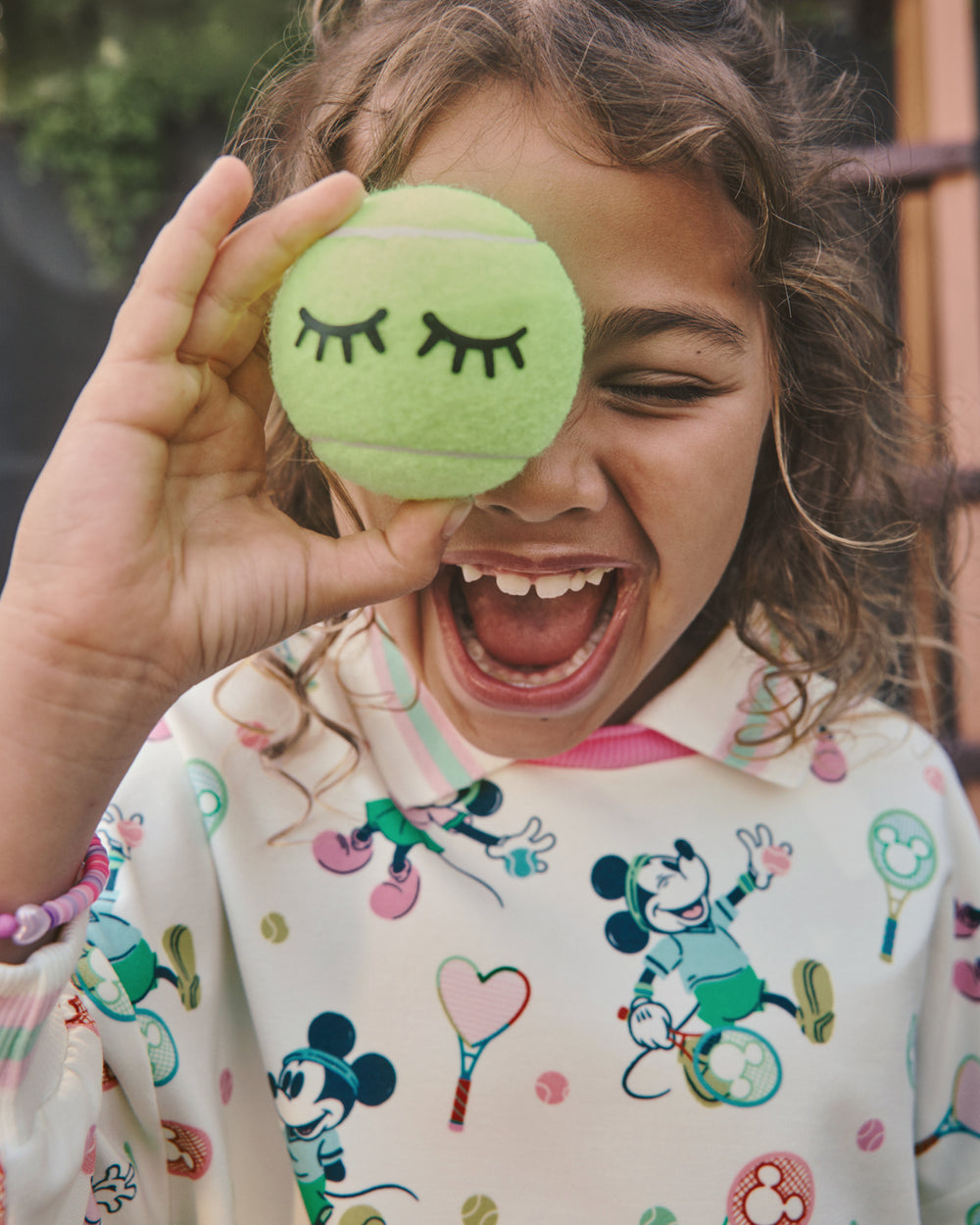Girl wearing the Disney Mickey Mouse & Minnie Mouse Match Drop Shoulder Crewneck holding a tennis ball