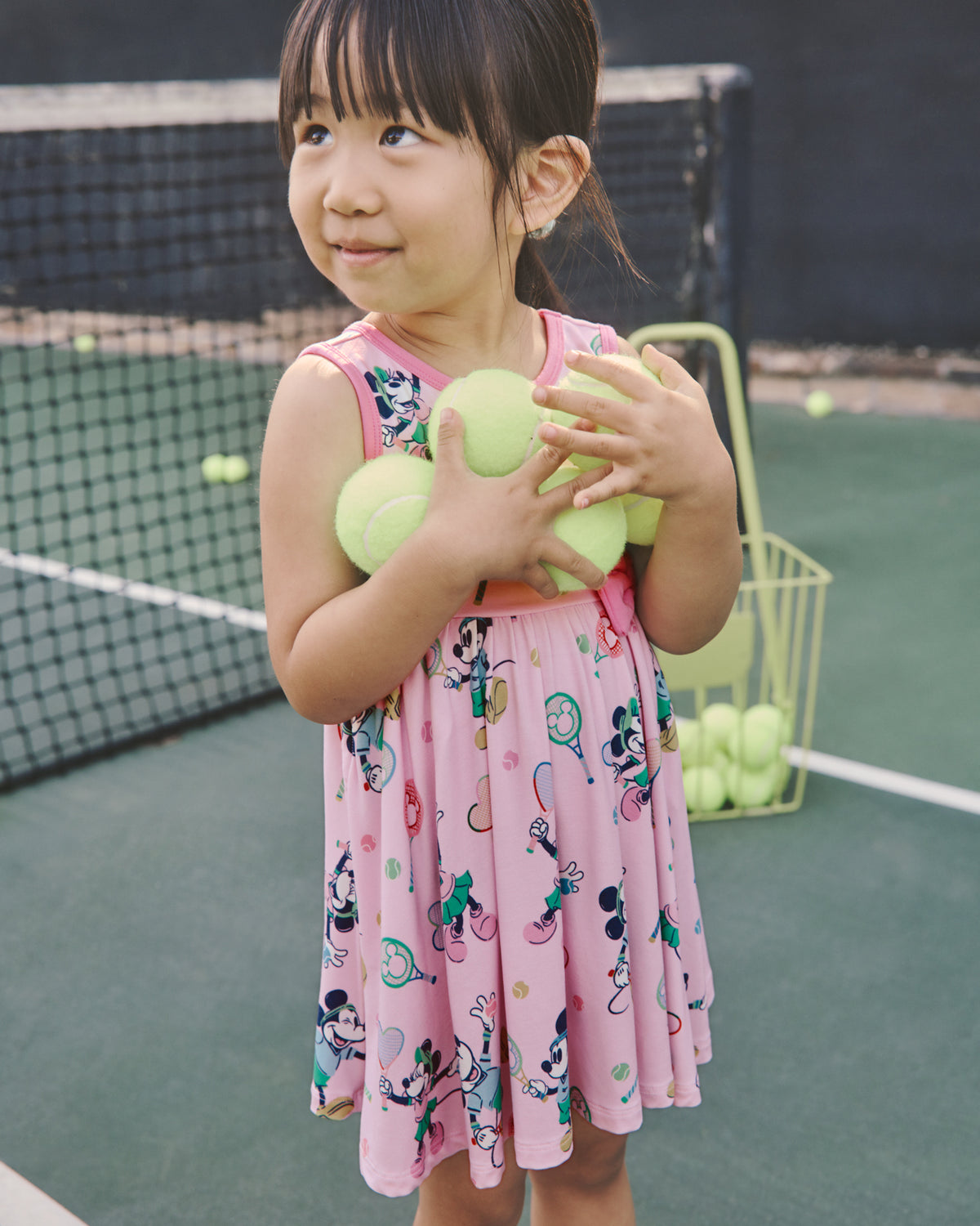 Girl wearing the Disney Mickey Mouse & Minnie Mouse Match Twirl Dress holding tennis balls