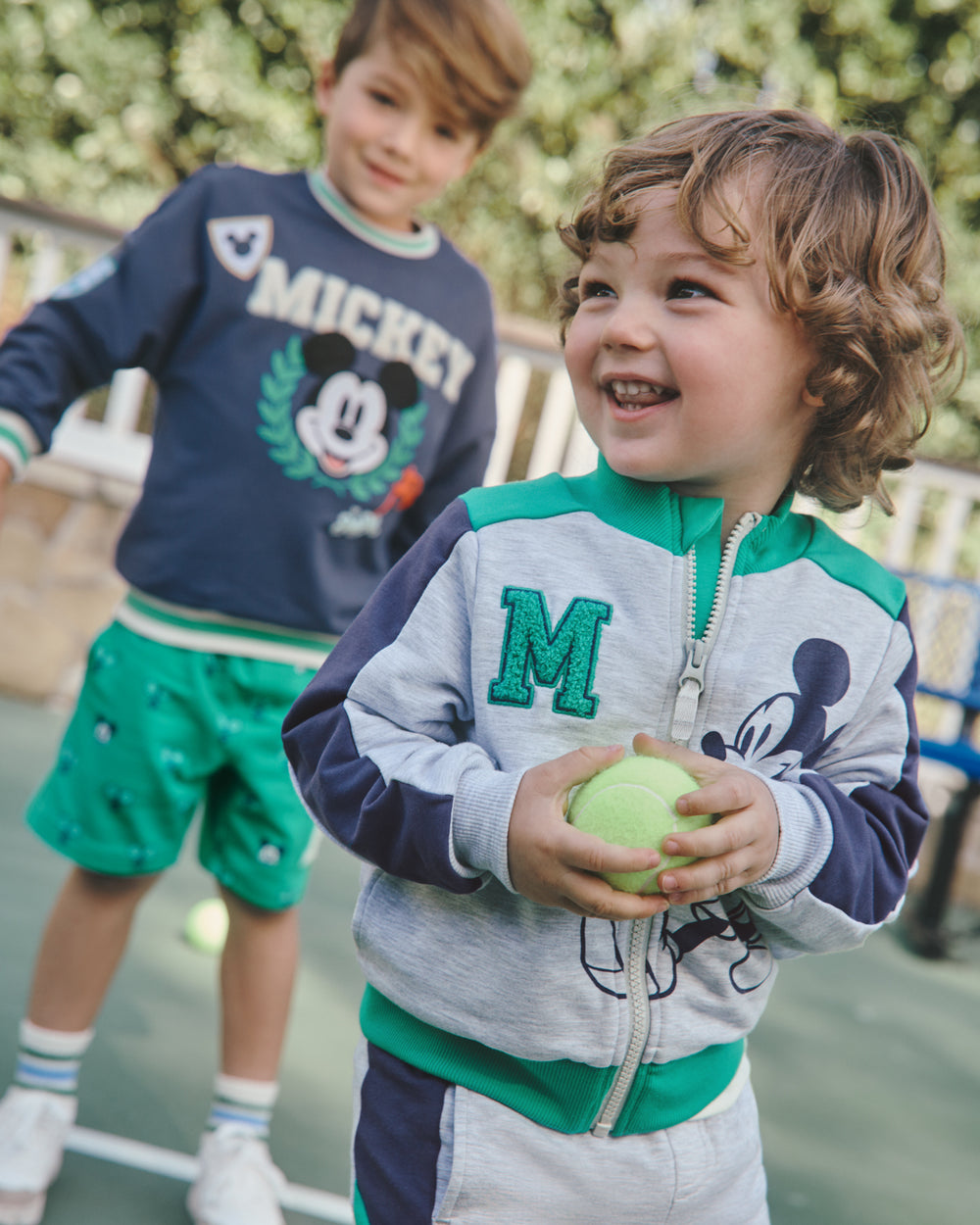 Child wearing the Disney Mickey Mouse Sports Club Track Jacket on a tennis court