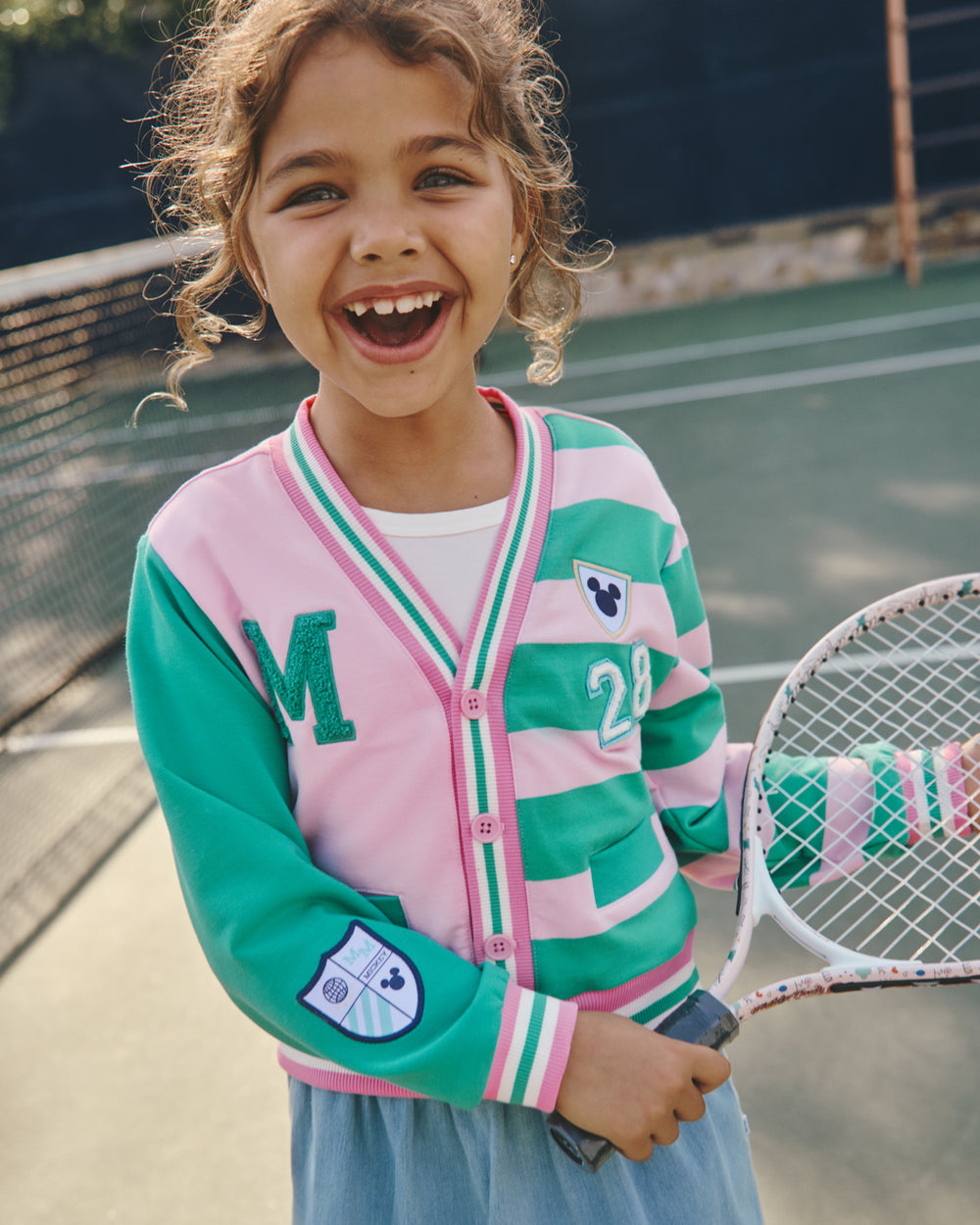 Girl wearing the Disney Mickey Mouse Sports Club Varsity Cardigan holding a tennis racket