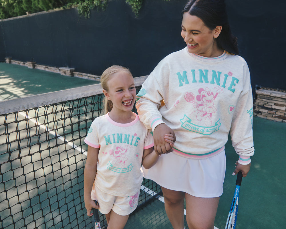 Woman and child wearing matching Disney Minnie Mouse Queen of Swing Tops on a tennis court