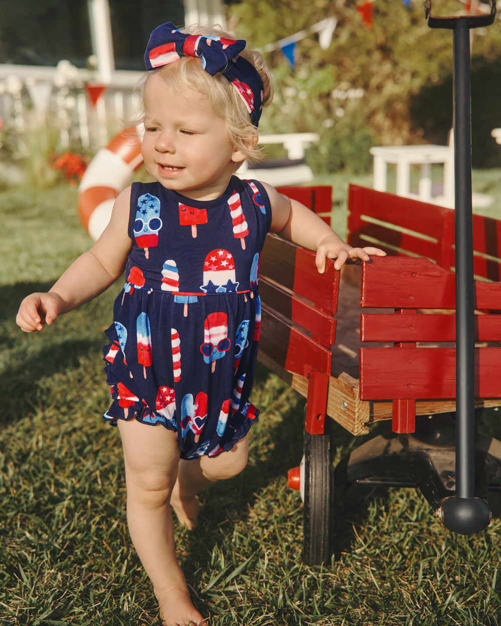 Girl wearing the Sparkle Treats Bubble Romper holding onto a red wagon