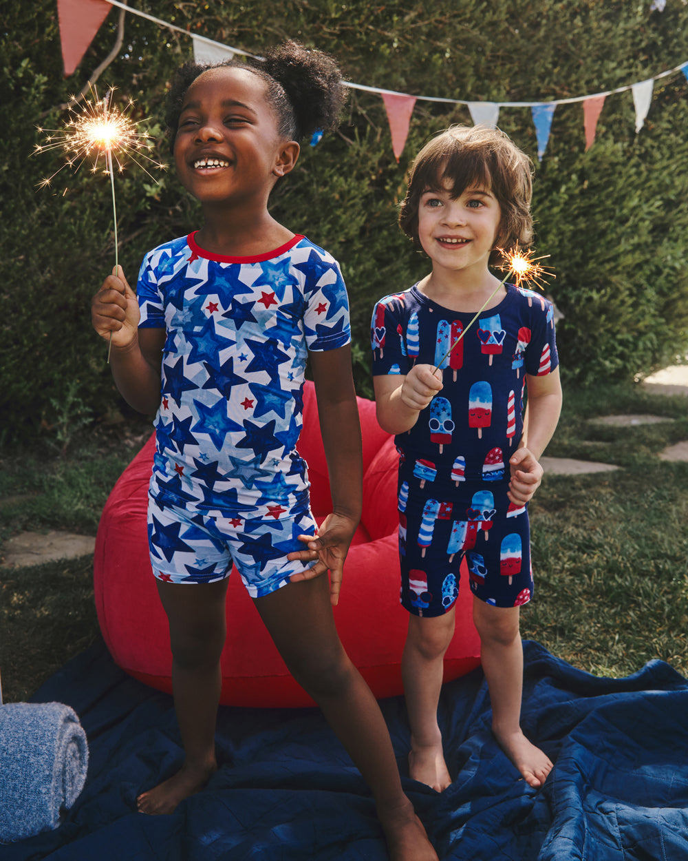 Two kids wearing 4th of July Kids Pajamas holding sparklers