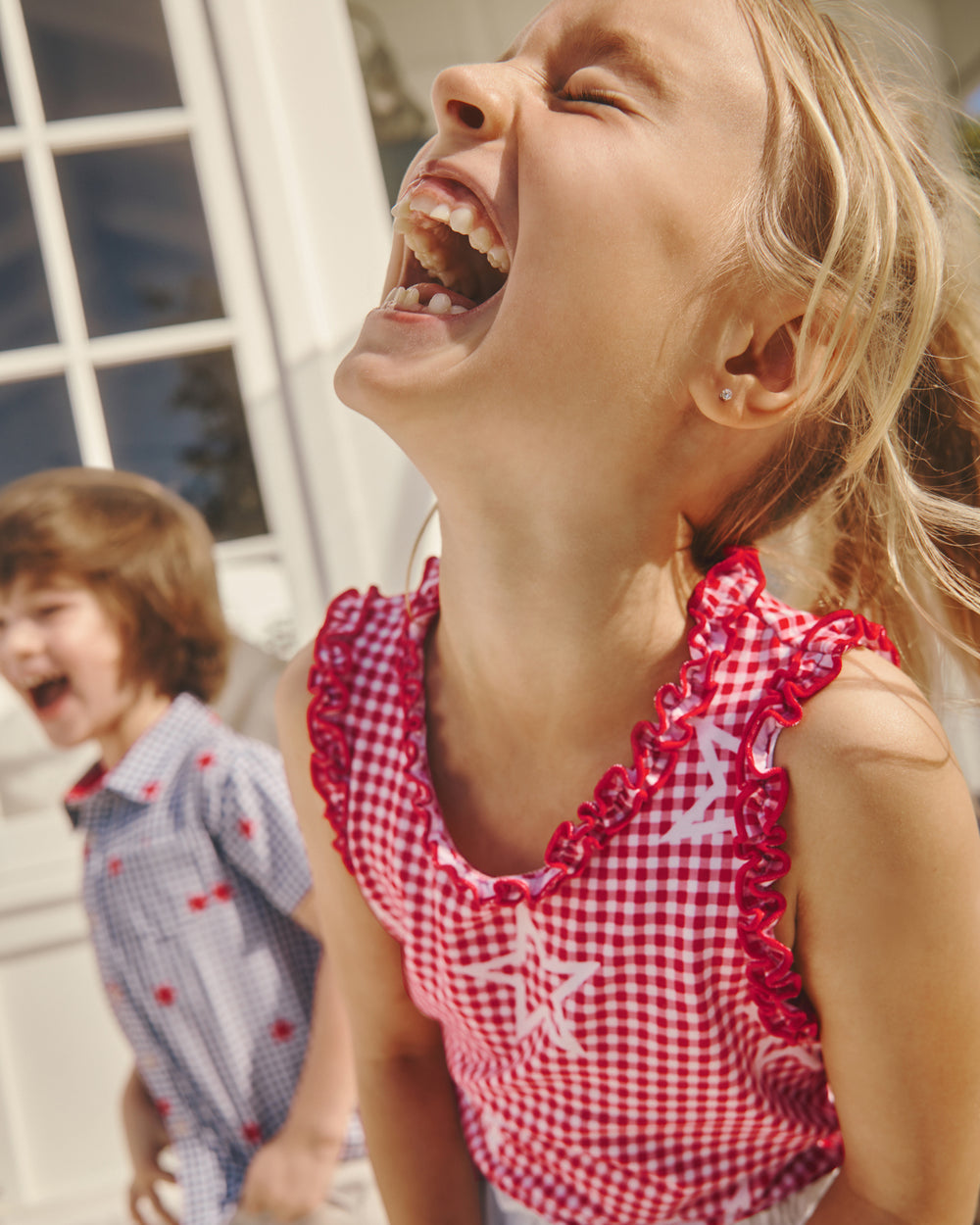 Laughing girl wearing the Celebration Gingham Ruffle Tank Top