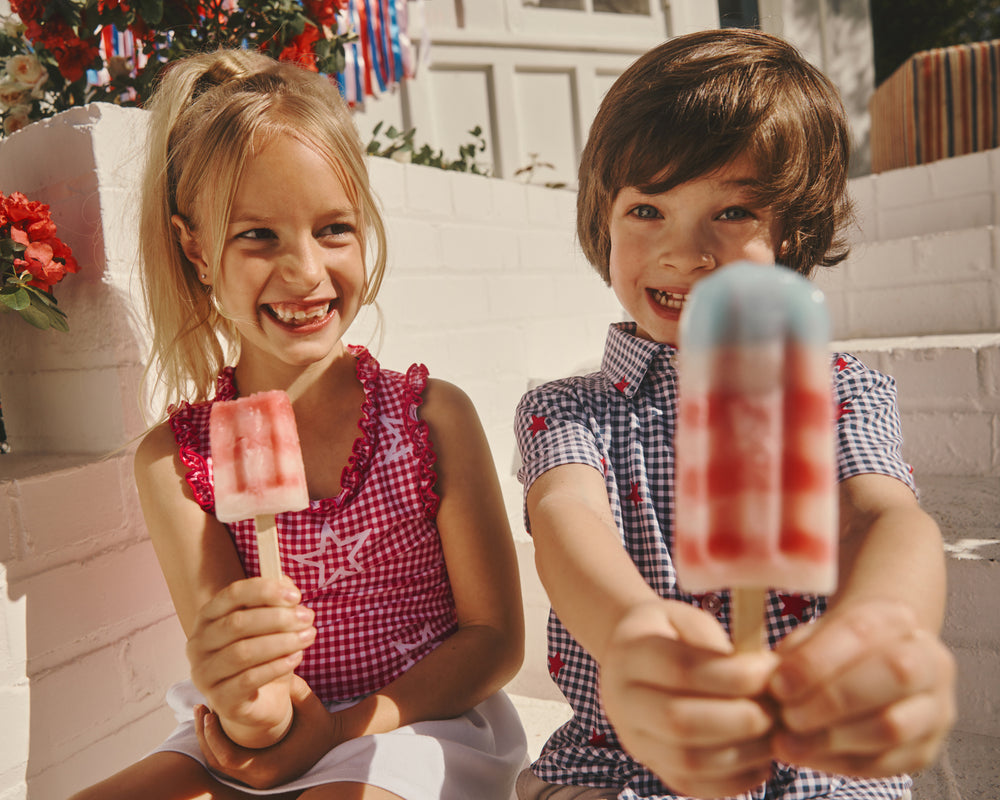 Two kids wearing Gingham Tops holding popsicles