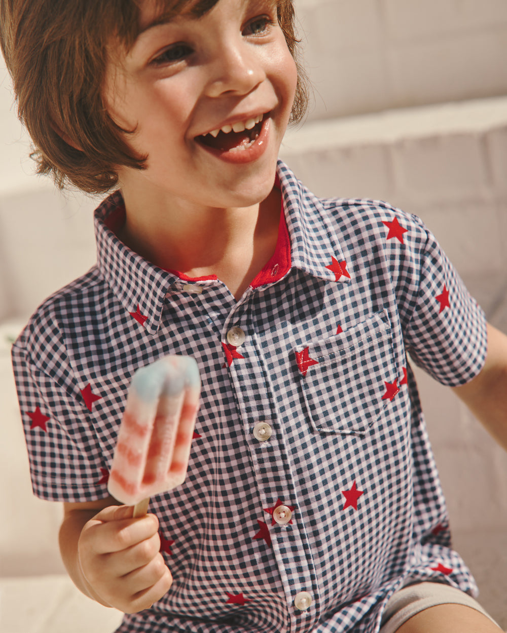 Boy wearing the Blue Ribbon Gingham Button Down Shirt holding a popsicle 