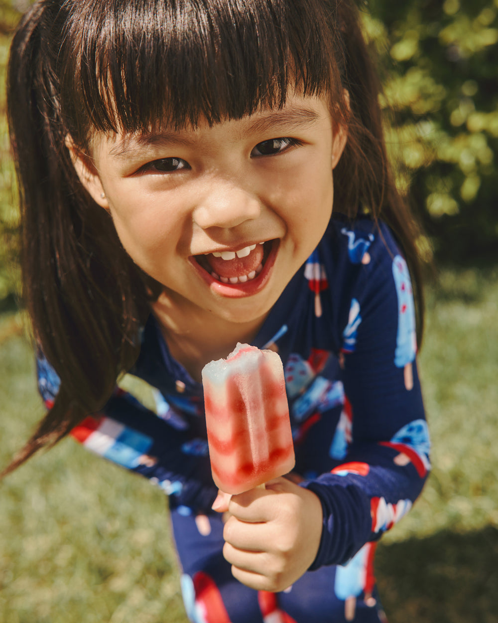 Girl wearing the Sparkle Treats Two-Piece Pajama Set holding a popsicle 
