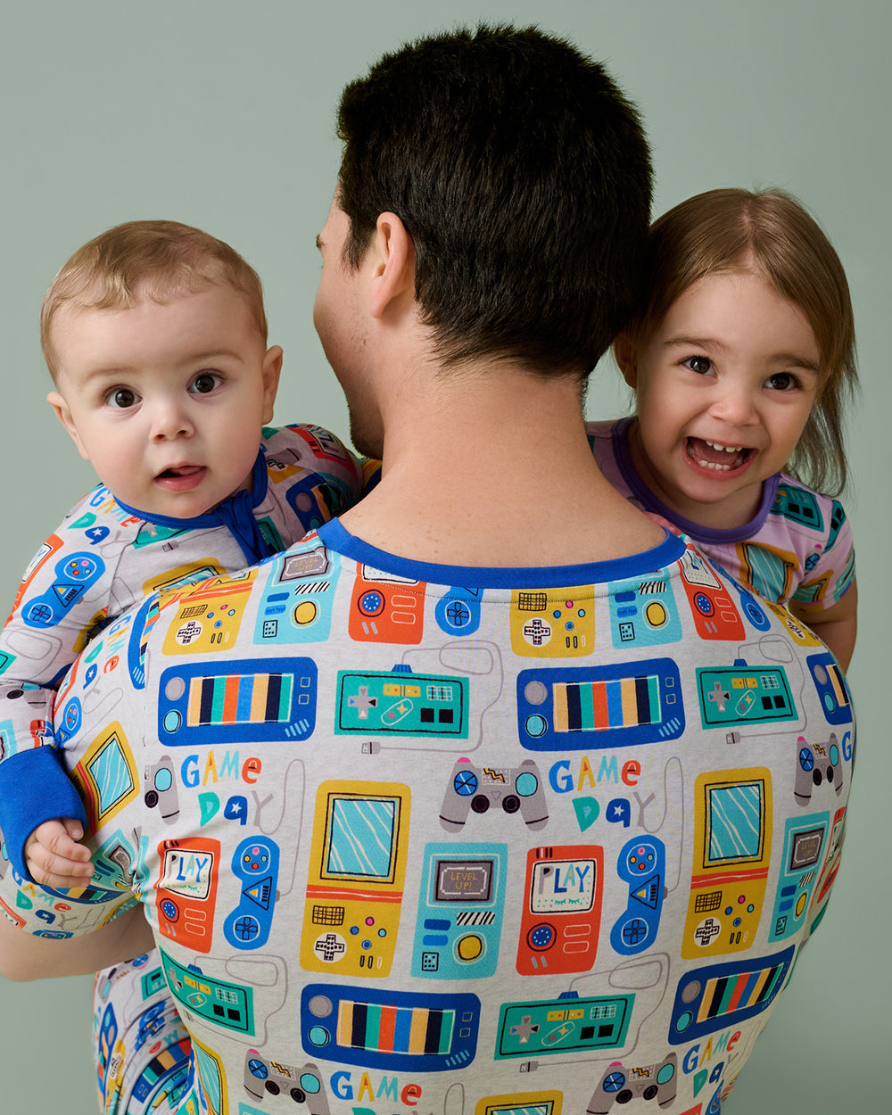 Man wearing the Game On Men's Short Sleeve Pajama Top holding two children