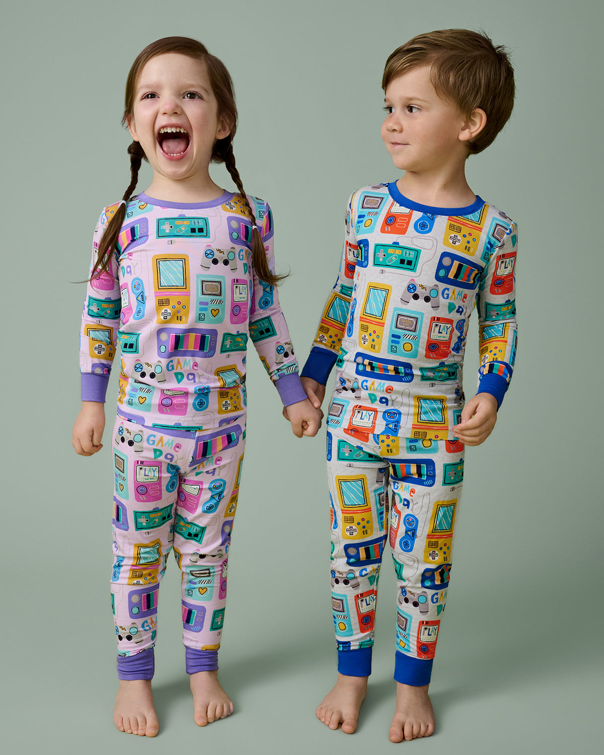 Two children wearing matching Game On Two-Piece Pajama Sets