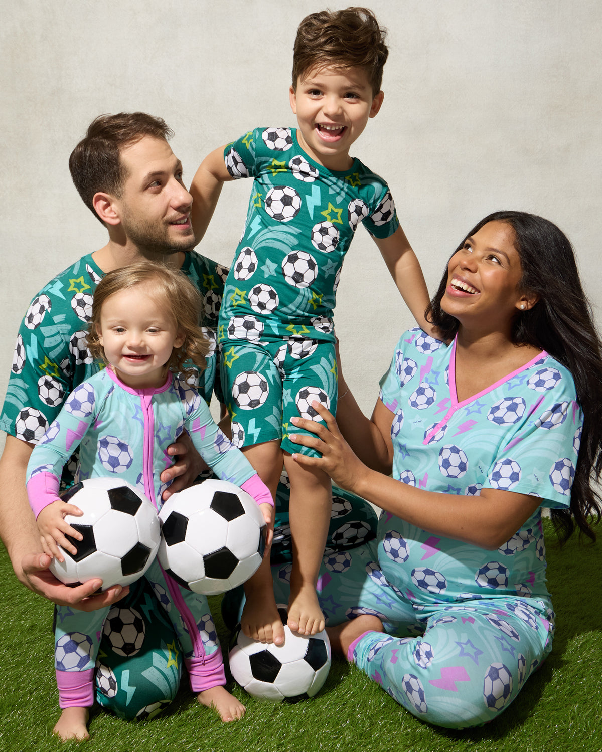 Family of four wearing matching Soccer Stars pajamas