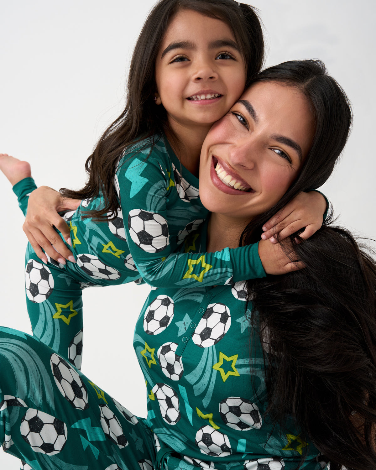 Close up of mother and daughter wearing matching Soccer Stars PJs