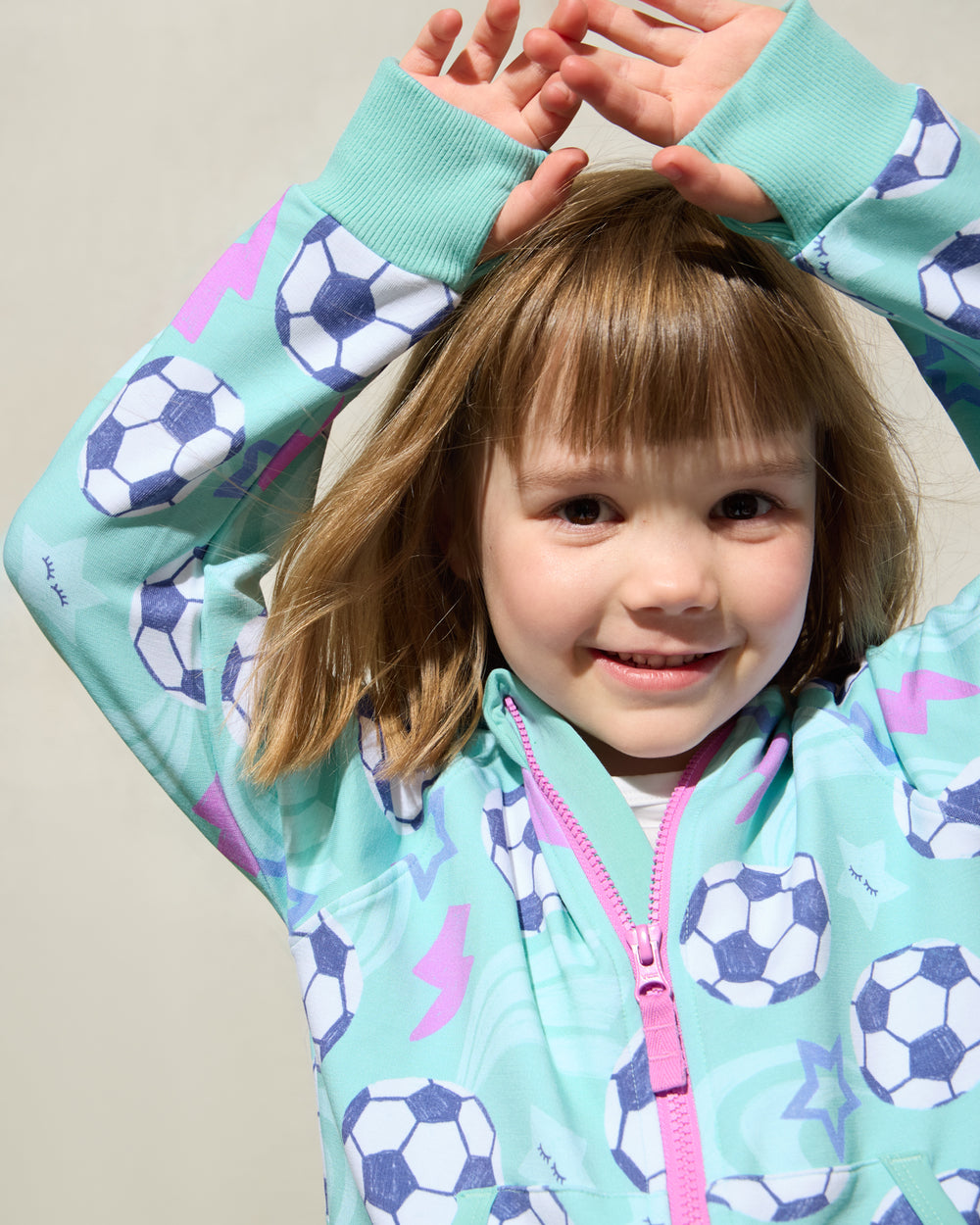Close up of girl wearing the Aqua Soccer Stars Zip Hoodie showing the thumb holes