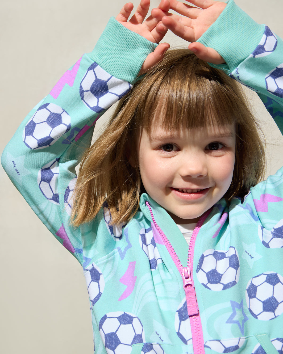 Close up of girl wearing the Aqua Soccer Stars Zip Hoodie showing the thumb holes