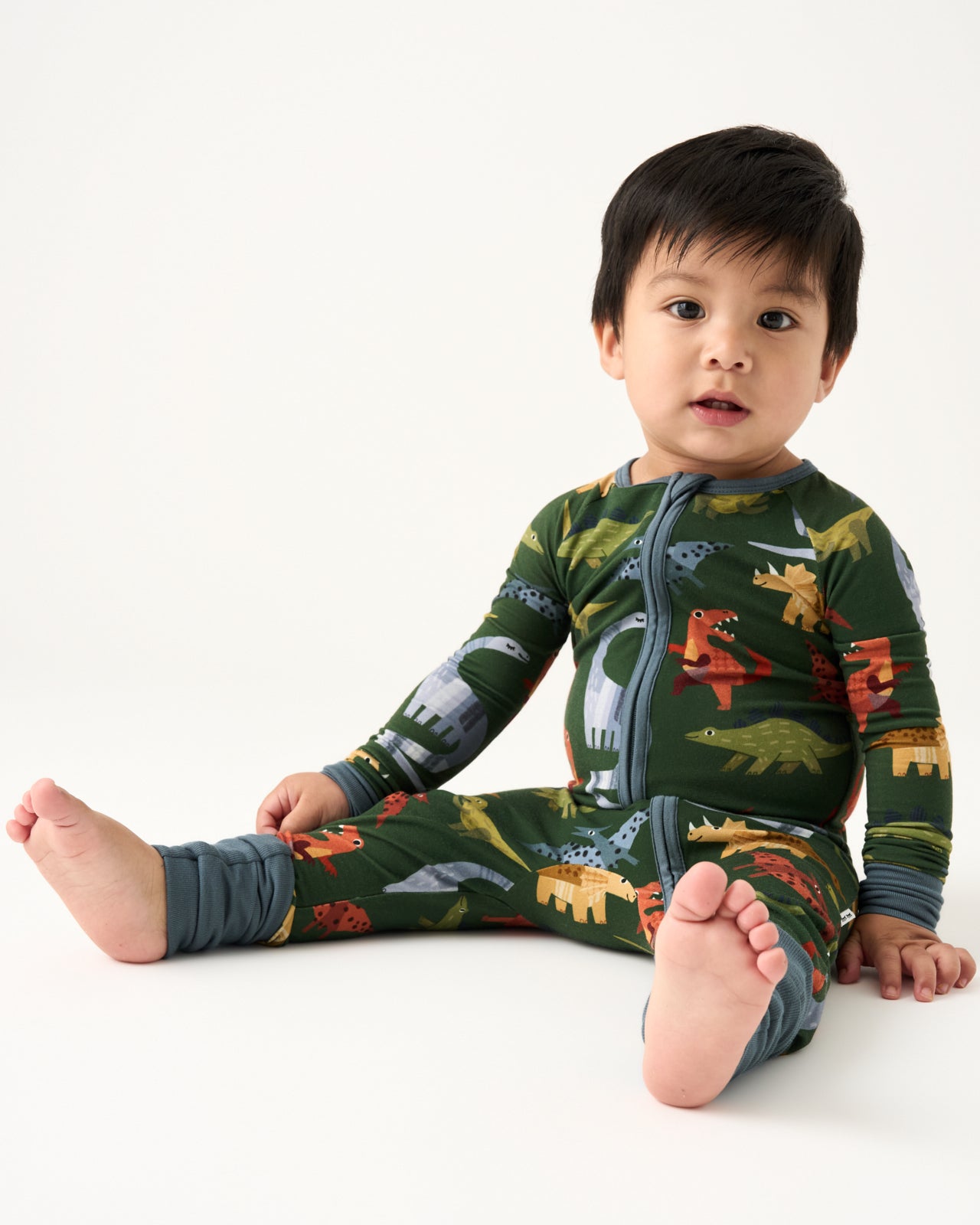 Sitting baby wearing the Green Roar & Explore Zippy