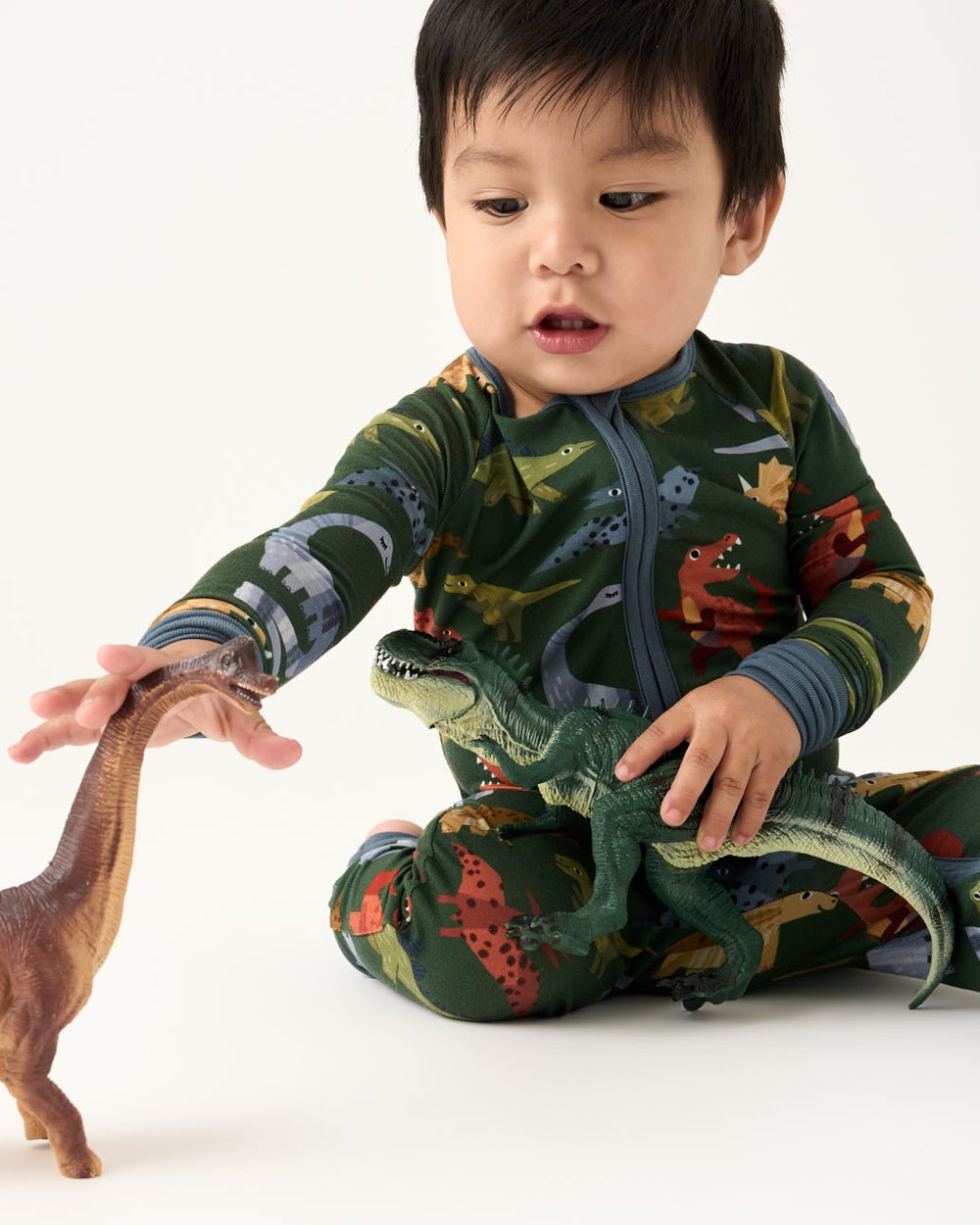 Alternate of baby wearing the Green Roar & Explore Zippy playing with dino toys
