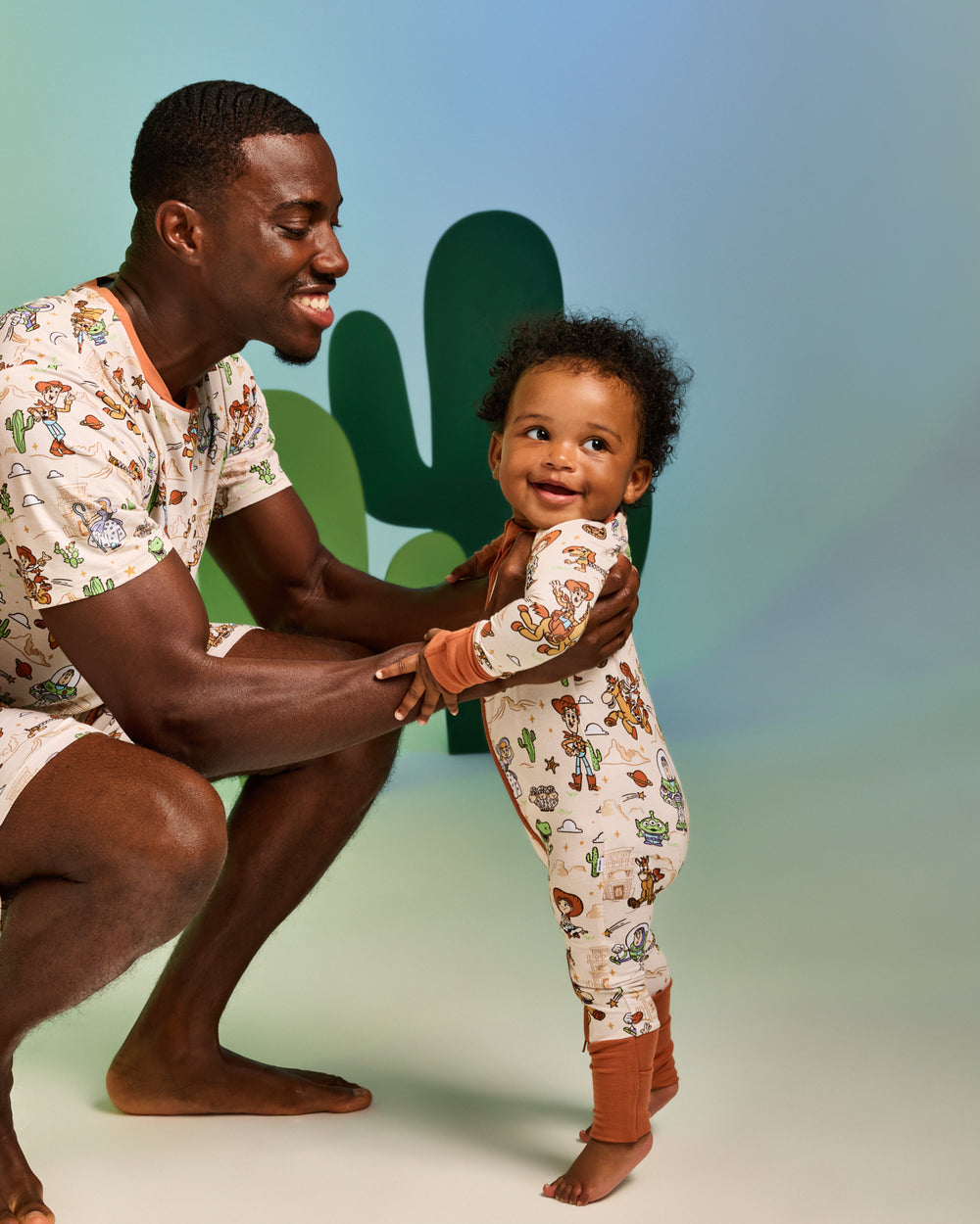 Father and baby wearing matching Disney & Pixar Woody's Wild West pajamas