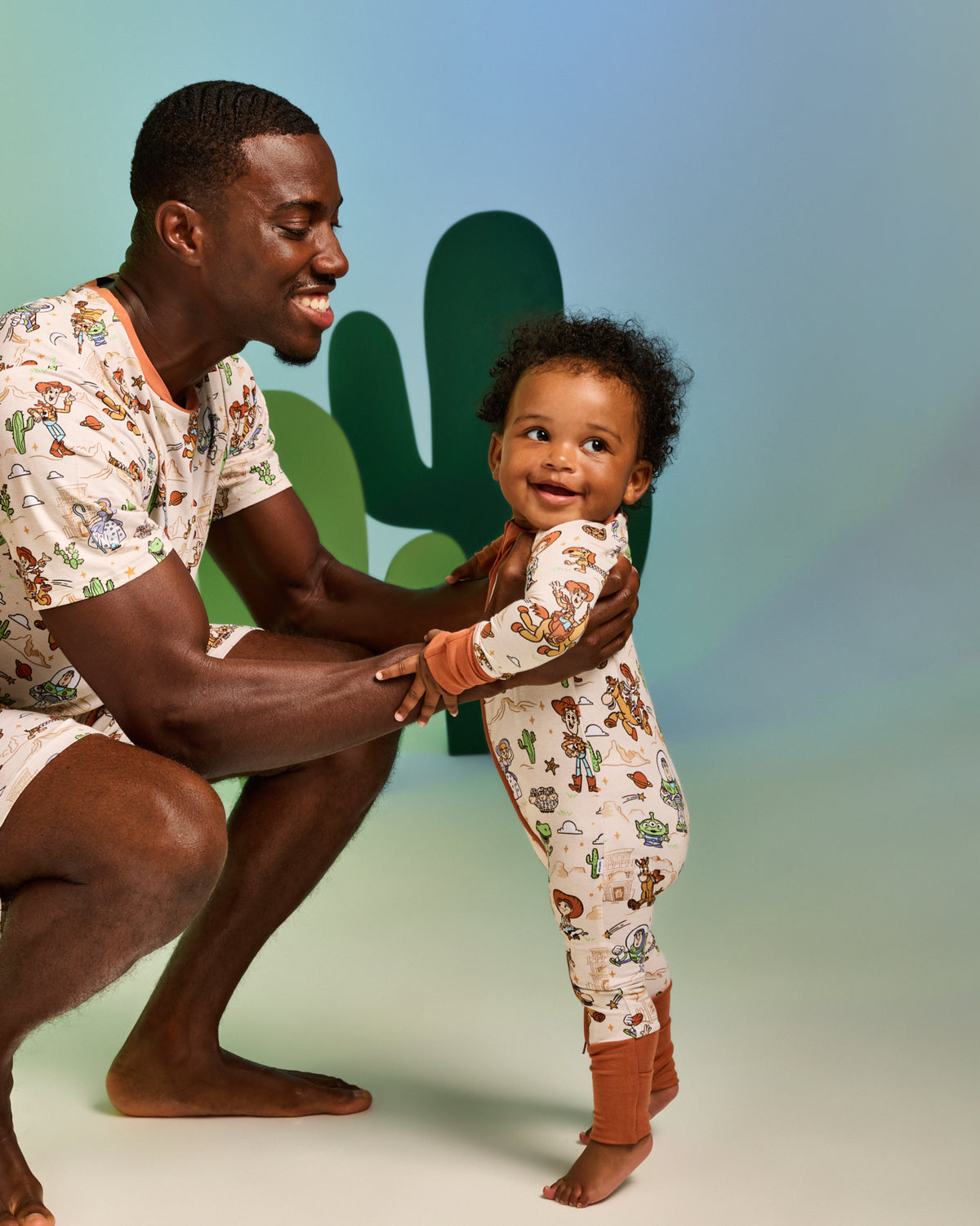Father and baby wearing matching Disney & Pixar Woody's Wild West pajamas