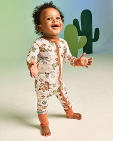 Standing baby wearing the Disney & Pixar Woody's Wild West Zippy on a green backdrop