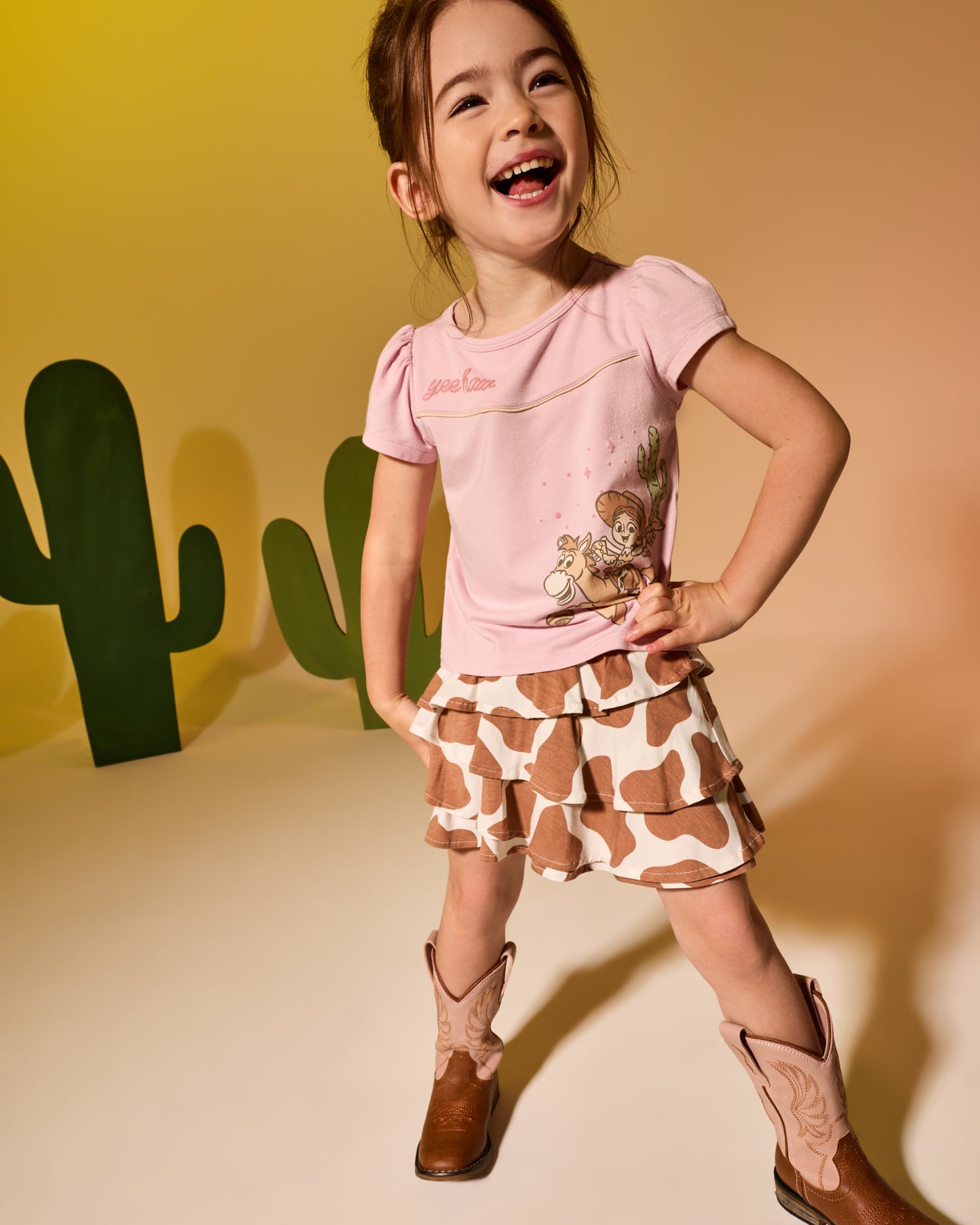 Girl wearing the Disney & Pixar Howdy Jessie Puff Sleeve Tee with the Milk Chocolate Moo Crew Ruffle Skort