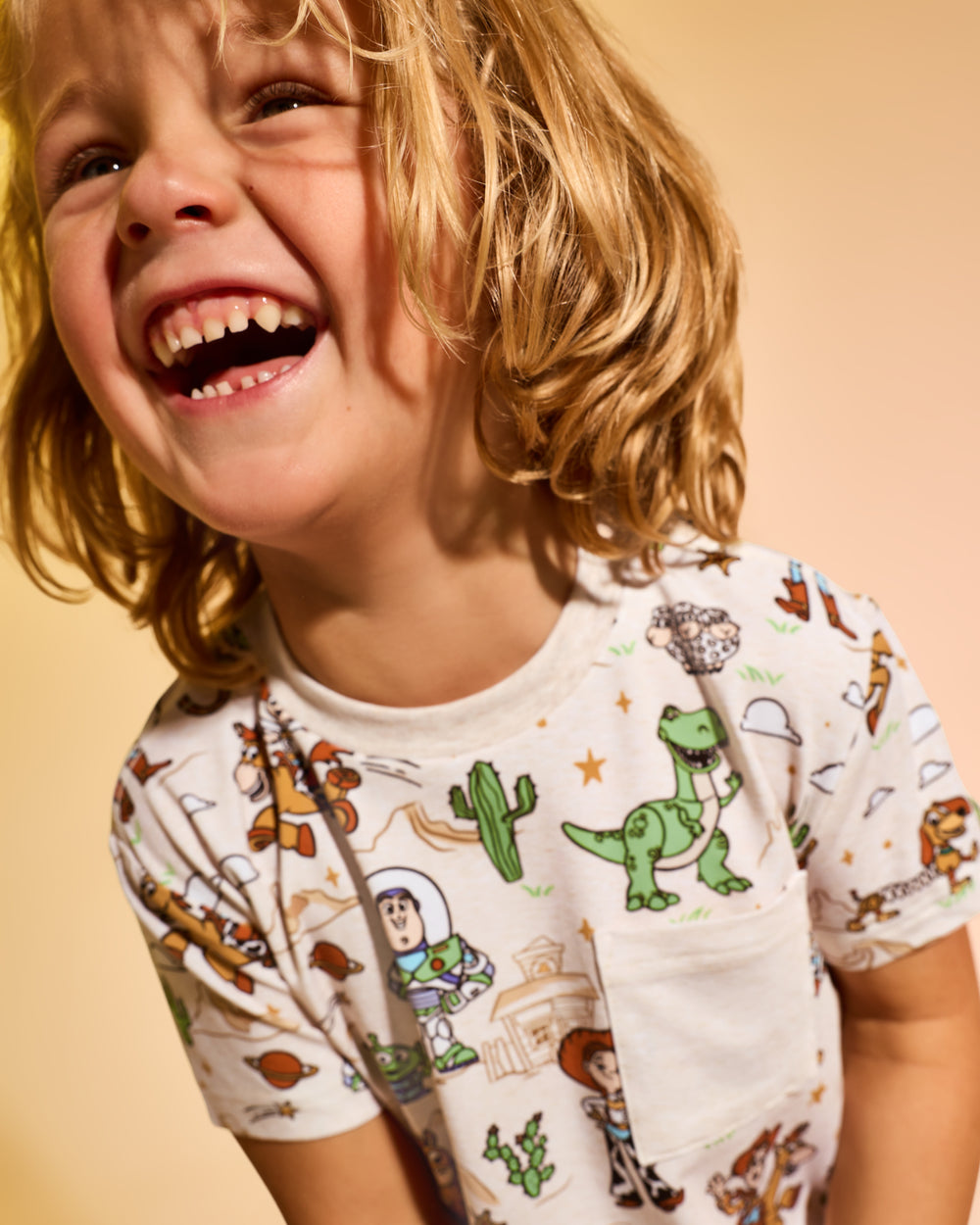 Close up of boy wearing the Disney & Pixar Woody's Wild West Relaxed Pocket Tee