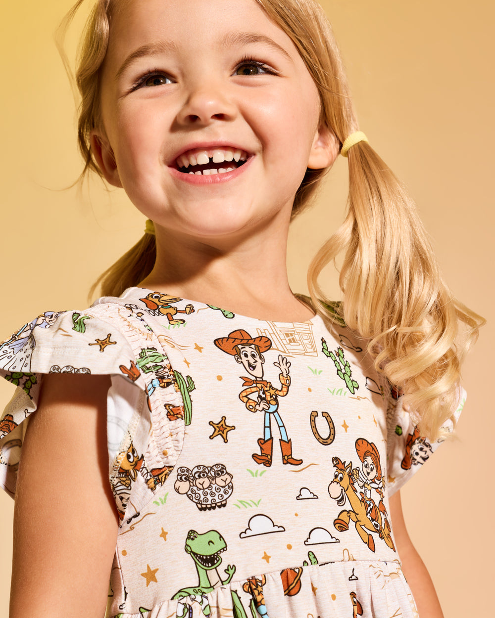 Close up of girl wearing the Disney & Pixar Woody's Wild West Tiered Flutter Dress