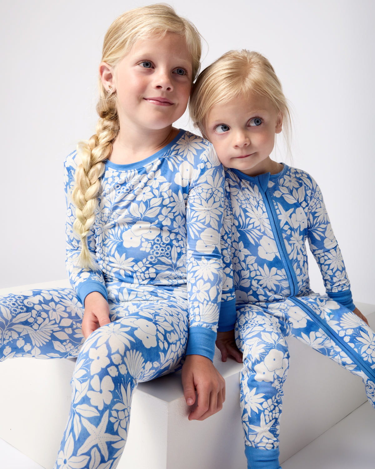 Two siblings wearing matching Azure Garden bamboo pajamas