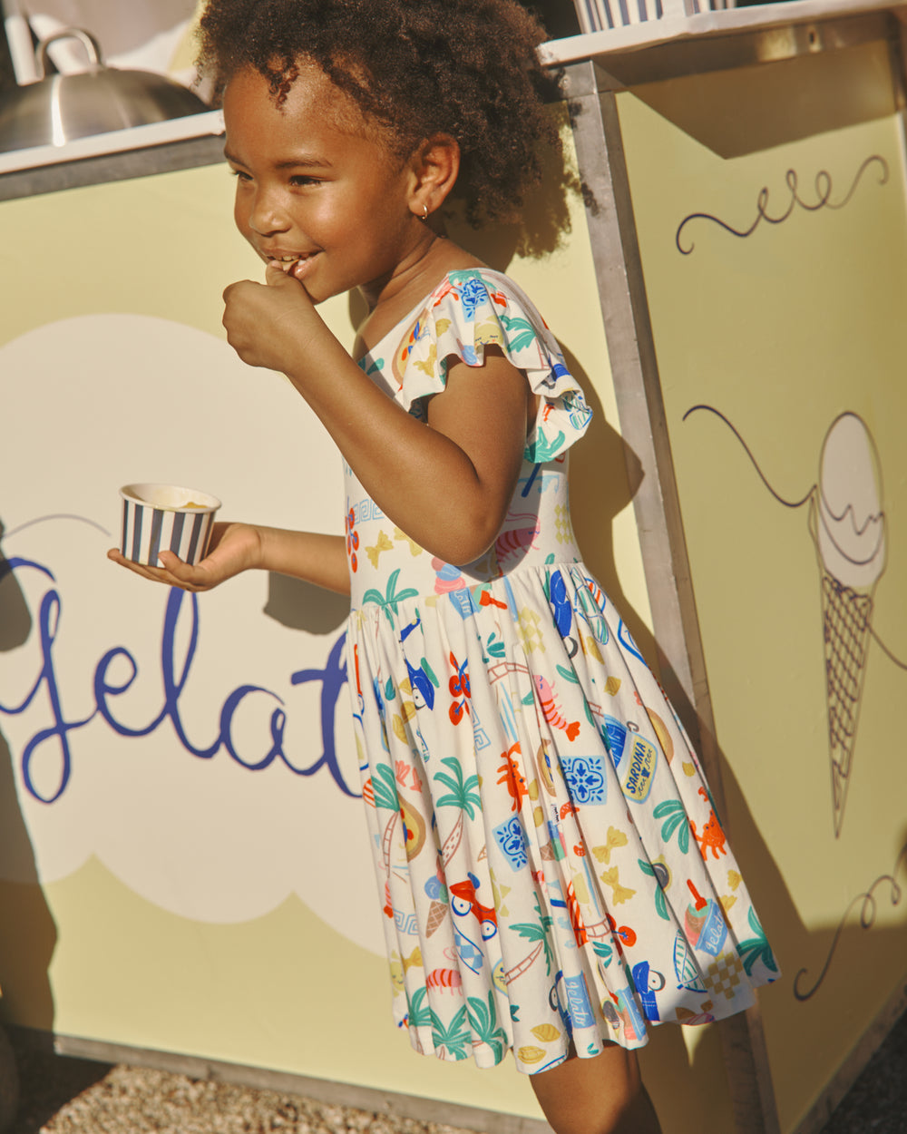 Child eating gelato in the Ciao Bella Flutter Twirl Dress