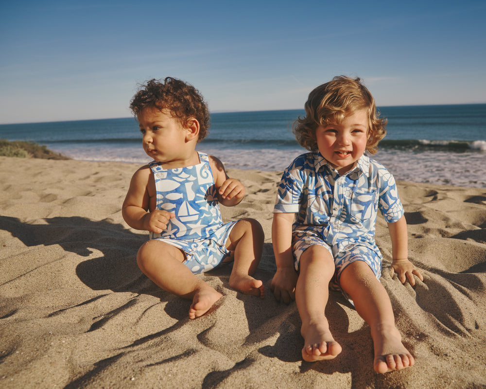 Two boys at the beach wearing matching Summer Shores daywear styles