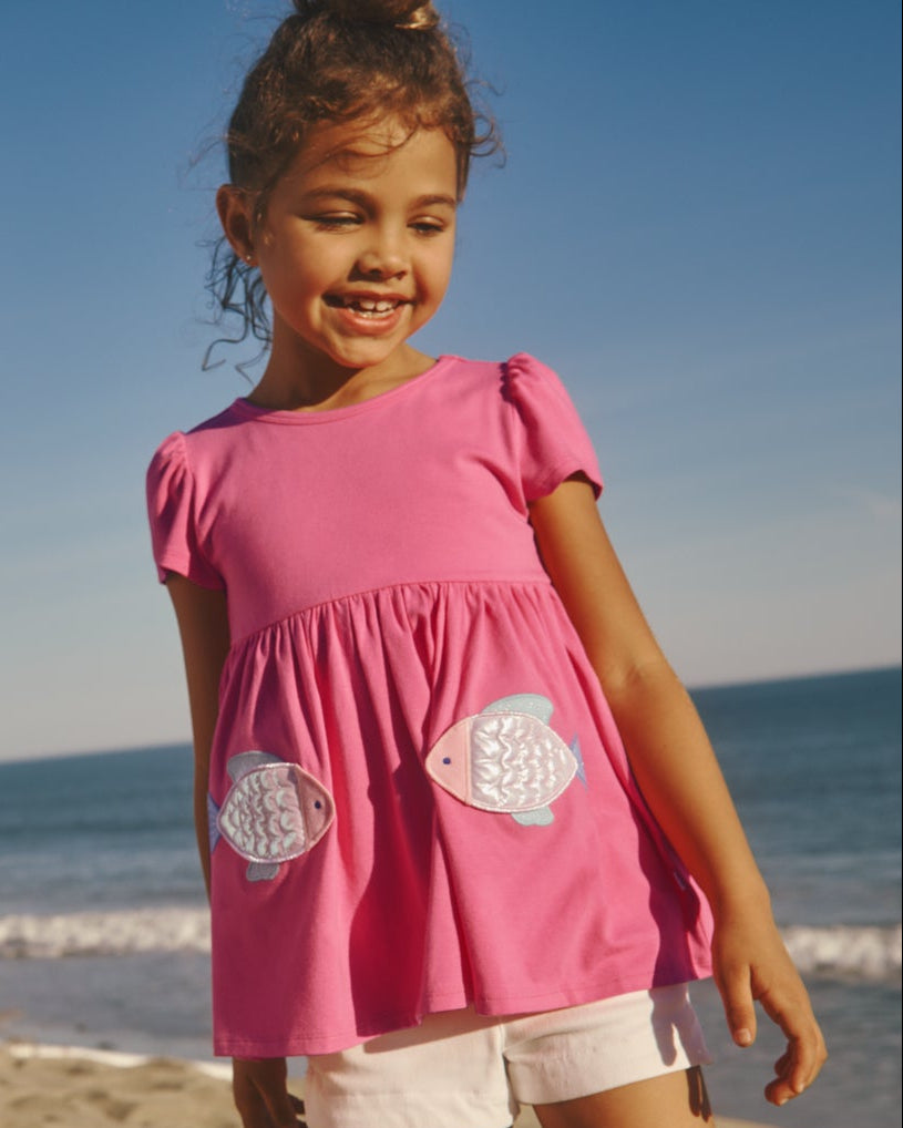 Girl wearing the Sparkling Scales Empire Tunic Top at the beach