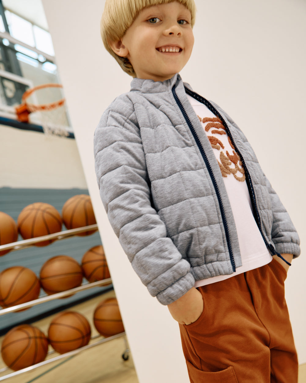 Boy wearing the Heather Gray Quilted Track Jacket in a gymnasium